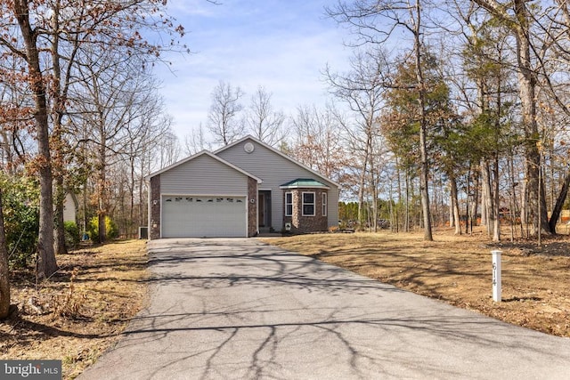 view of front facade with aphalt driveway, a garage, and brick siding