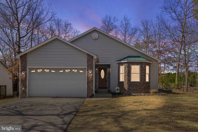 view of front facade featuring stone siding, a garage, and driveway