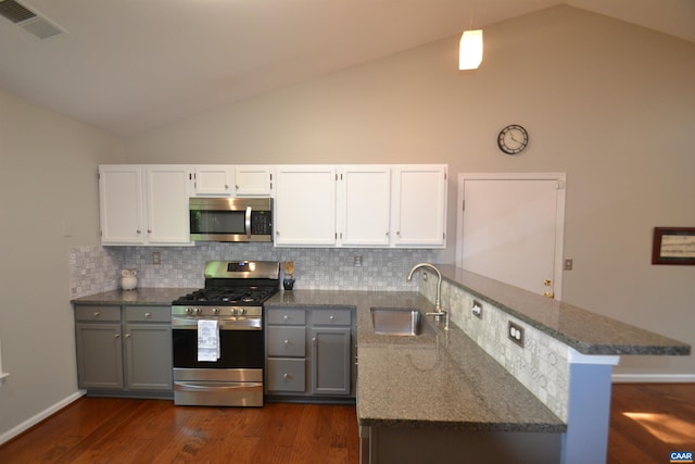 2090 Tavernor Ln, Charlottesville, VA 22911 - kitchen with stainless steel appliances, vaulted ceiling, a peninsula, dark stone counters, and dark wood-style flooring