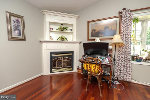  - sitting room with wood finished floors, a fireplace, and an office area