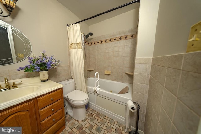  - full bathroom with tile walls, vanity, shower / bath combination with curtain, and a wainscoted wall
