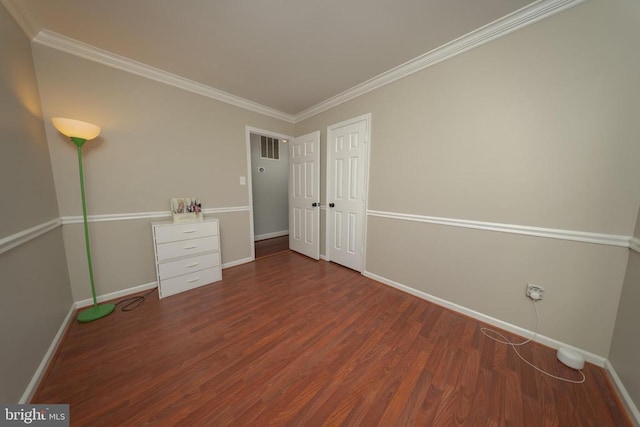  - unfurnished bedroom with wood finished floors, crown molding, and a closet