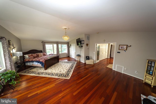  - bedroom with vaulted ceiling, wood finished floors, and a chandelier