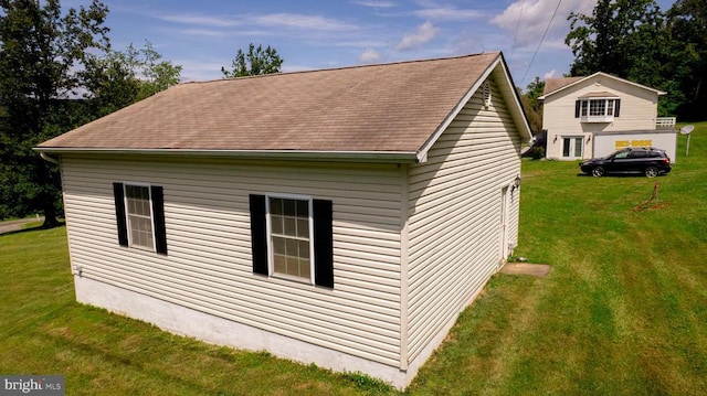  - view of side of property with a lawn and a shingled roof