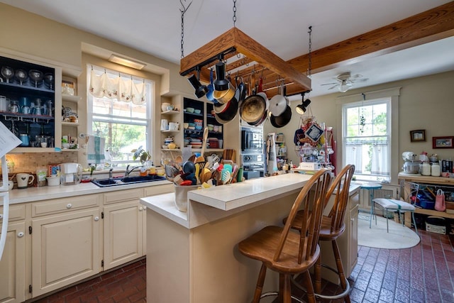 289 Newman Ave, Harrisonburg, VA 22801 - kitchen with brick flooring, a sink, open shelves, light countertops, and beamed ceiling