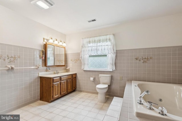  - bathroom with tile walls, vanity, toilet, and tile patterned flooring