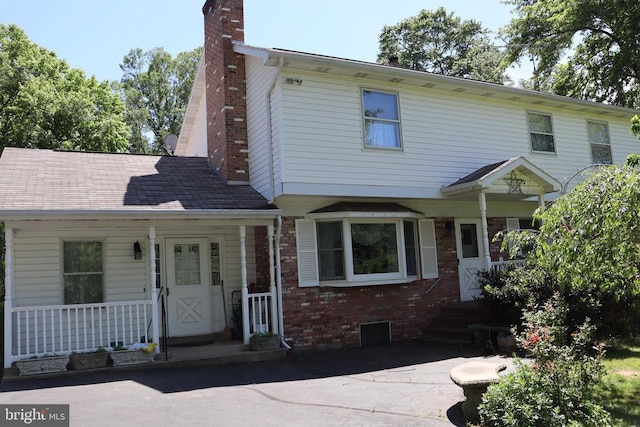  - multi unit property with a chimney, brick siding, and a porch