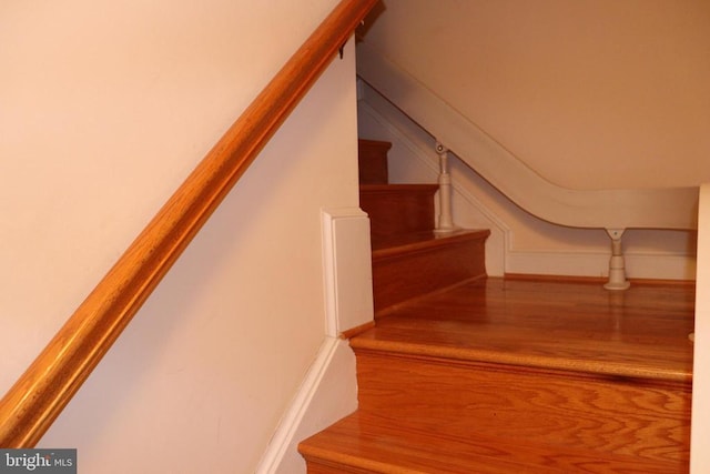  - stairs featuring wood finished floors