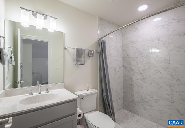 full bathroom with tiled shower, toilet, and vanity