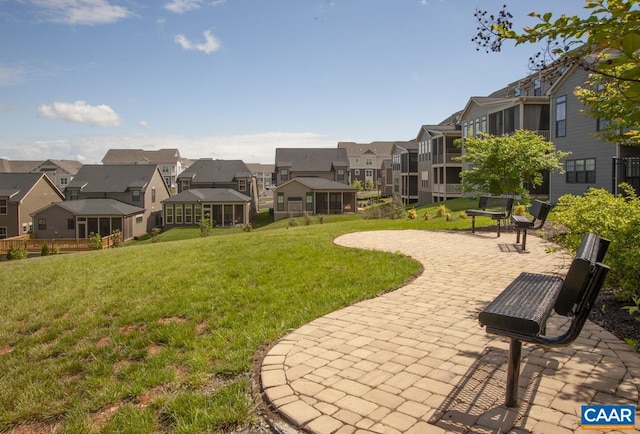 view of community featuring a residential view, a patio, and a lawn