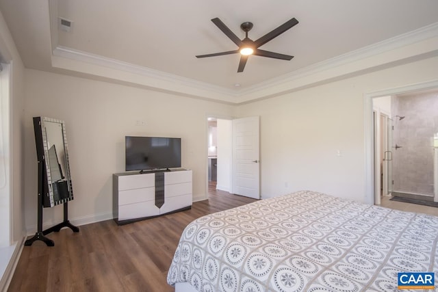bedroom featuring wood finished floors, ornamental molding, a raised ceiling, and baseboards