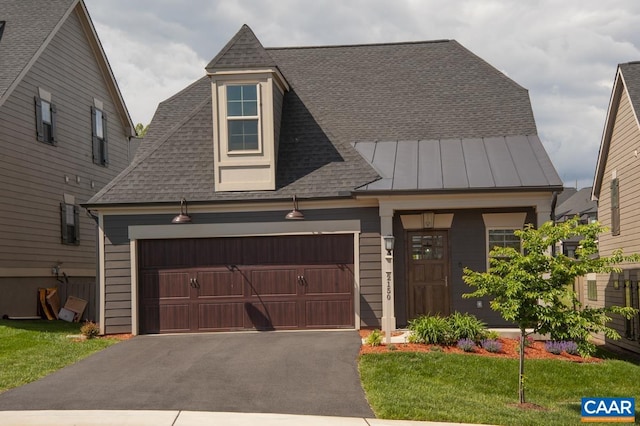 view of front of house with driveway, roof with shingles, a garage, a standing seam roof, and a front yard