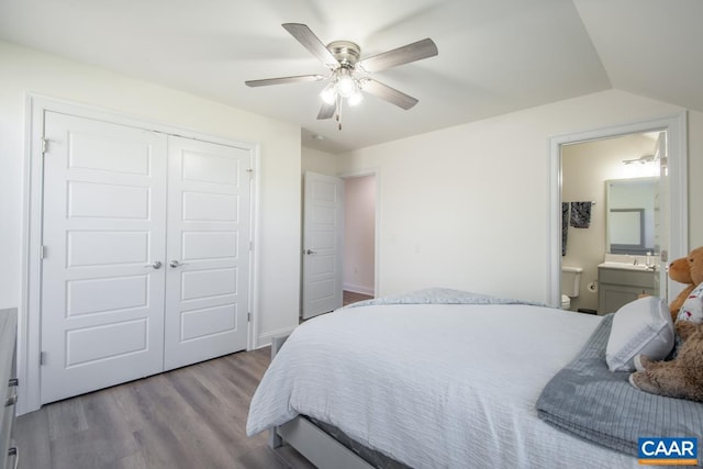 bedroom featuring wood finished floors, a closet, a ceiling fan, and ensuite bathroom