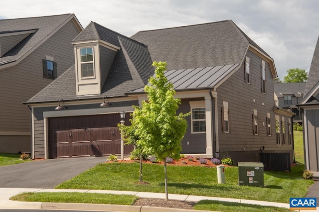 view of front of home featuring driveway, a front lawn, a standing seam roof, a shingled roof, and an attached garage