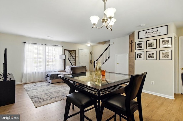 7688 Wankoma Dr, Remington, VA 22734 - dining room with stairway, light wood-style flooring, a chandelier, and baseboards