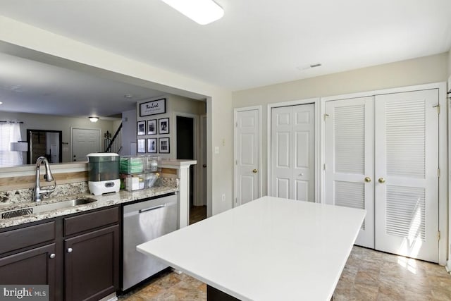 7688 Wankoma Dr, Remington, VA 22734 - kitchen with stainless steel dishwasher, a sink, dark brown cabinets, a kitchen island, and light stone counters