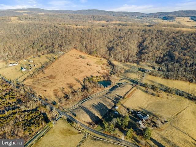  - aerial view of property's location featuring a heavily wooded area and a mountain backdrop