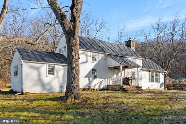  - modern farmhouse with a standing seam roof, a chimney, a front lawn, and metal roof