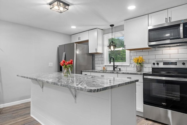 14372 E Side Hwy S, Grottoes, VA 24401 - kitchen featuring stainless steel appliances, a sink, a kitchen island, decorative backsplash, and white cabinetry