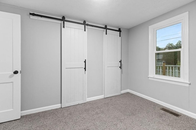 14372 E Side Hwy S, Grottoes, VA 24401 - unfurnished bedroom featuring a barn door, carpet floors, baseboards, and a closet