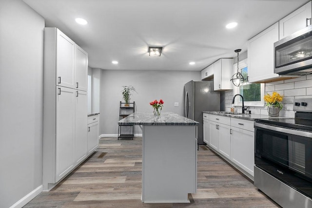 14372 E Side Hwy S, Grottoes, VA 24401 - kitchen with appliances with stainless steel finishes, a sink, a center island, decorative backsplash, and white cabinets