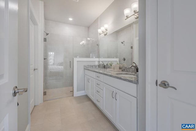 full bath featuring a sink, double vanity, a shower stall, and tile patterned flooring