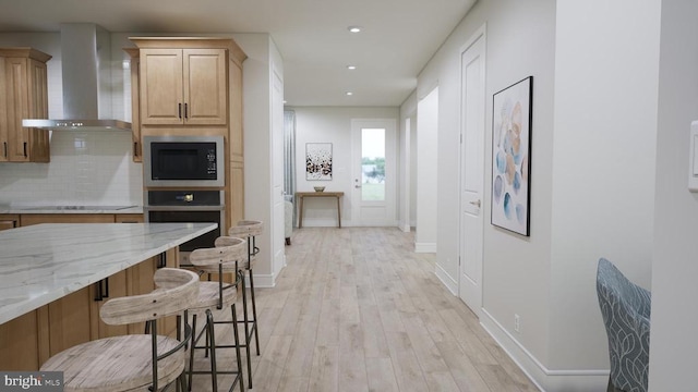 kitchen with backsplash, built in microwave, a kitchen bar, stainless steel oven, and wall chimney exhaust hood