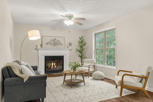 740 Confederacy Dr, Penn Laird, VA 22846 - living room featuring baseboards, wood finished floors, a fireplace with flush hearth, and ceiling fan