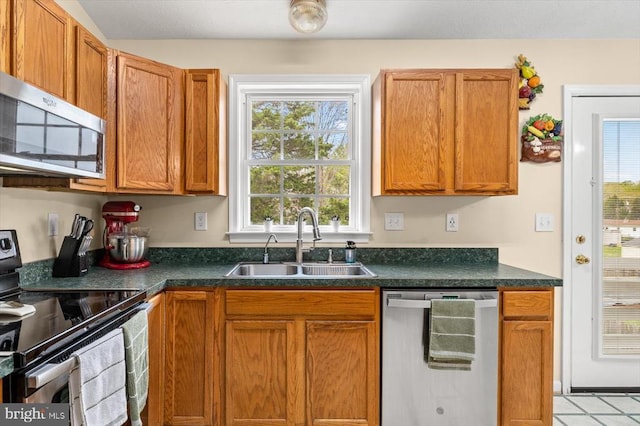 12006 Falcon Ridge Dr, Fredericksburg, VA 22407 - kitchen with appliances with stainless steel finishes, a sink, dark countertops, and brown cabinetry