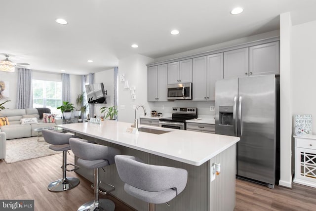 3801 Drayton Ct, Fredericksburg, VA 22408 - kitchen with stainless steel appliances, gray cabinets, open floor plan, wood finished floors, and a breakfast bar area