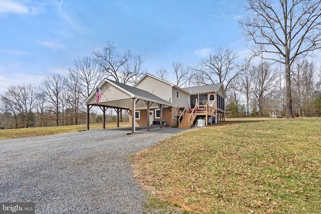 9107 Grasty Gold Mine Rd, Rhoadesville, VA 22542 - view of front of house with a sunroom, gravel driveway, an attached carport, a front yard, and stairs