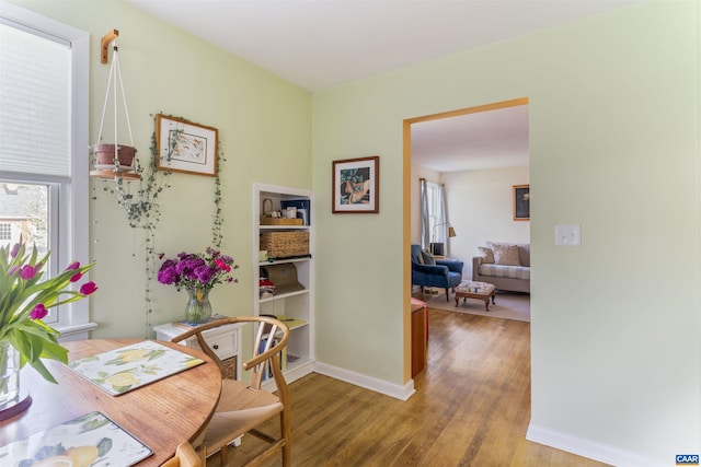dining space featuring light wood-type flooring and baseboards