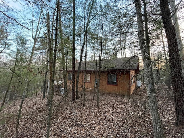 view of property exterior with a shingled roof