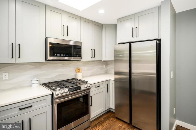 14906 Laurel Point Ln, Spotsylvania, VA 22551 - kitchen with appliances with stainless steel finishes, dark wood-style floors, light countertops, decorative backsplash, and recessed lighting
