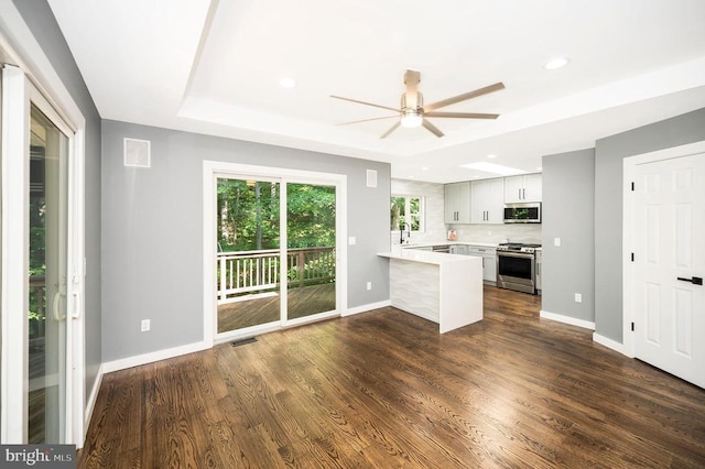 14906 Laurel Point Ln, Spotsylvania, VA 22551 - kitchen with appliances with stainless steel finishes, a peninsula, ceiling fan, light countertops, and a raised ceiling
