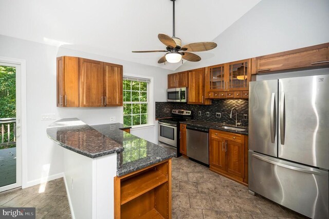 14906 Laurel Point Ln, Spotsylvania, VA 22551 - kitchen with appliances with stainless steel finishes, brown cabinetry, backsplash, glass insert cabinets, and lofted ceiling