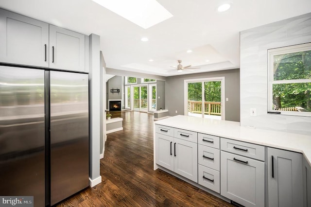 14906 Laurel Point Ln, Spotsylvania, VA 22551 - kitchen featuring freestanding refrigerator, a raised ceiling, dark wood-style floors, a skylight, and gray cabinets