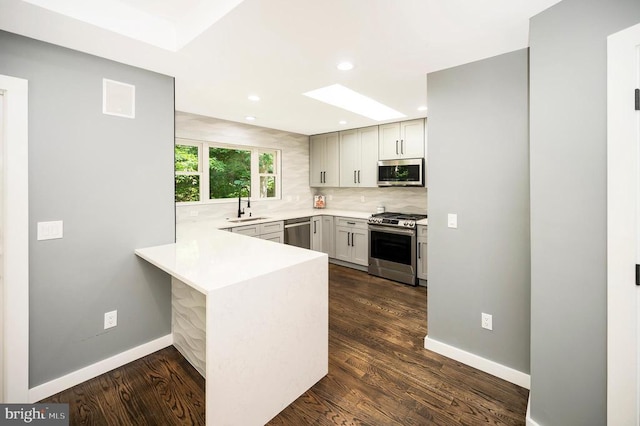 14906 Laurel Point Ln, Spotsylvania, VA 22551 - kitchen featuring stainless steel appliances, a peninsula, tasteful backsplash, light countertops, and dark wood-style flooring