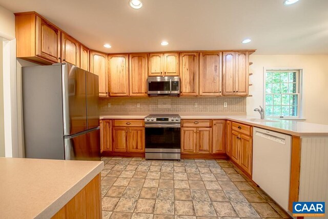 18220 Gregory Dr, Gordonsville, VA 22942 - kitchen with a peninsula, decorative backsplash, light countertops, stone finish flooring, and appliances with stainless steel finishes