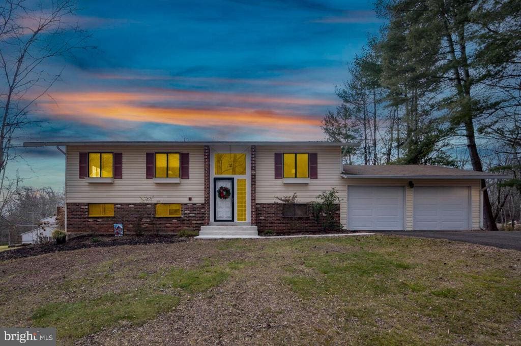 raised ranch with a yard and a garage