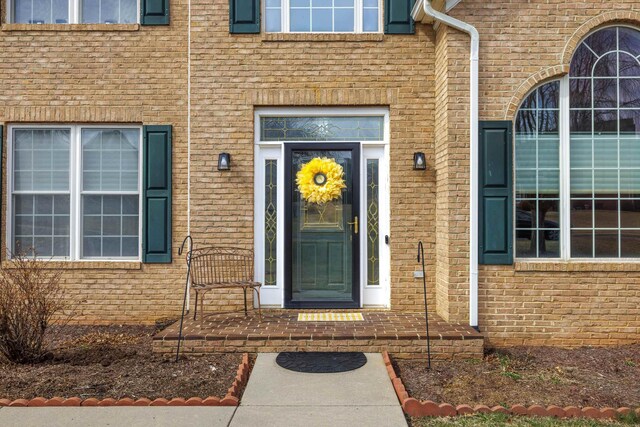 view of exterior entry with brick siding