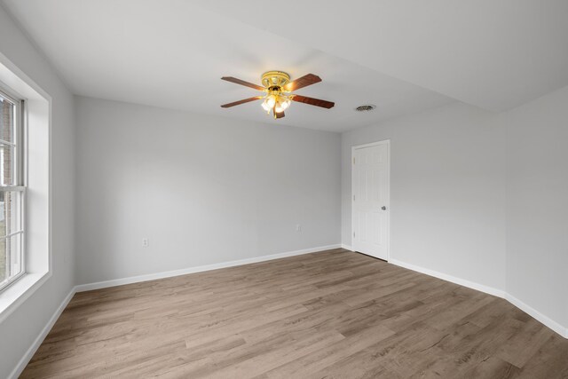 unfurnished room featuring ceiling fan, wood finished floors, and baseboards