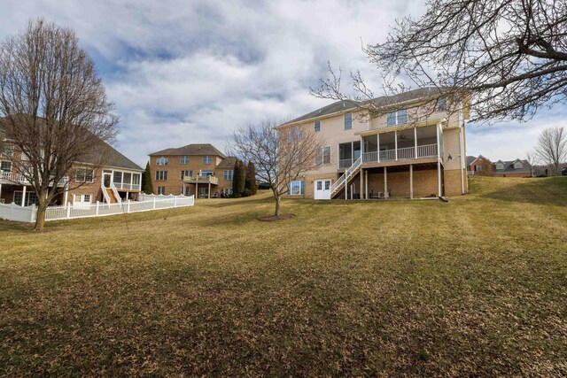 rear view of property featuring a sunroom and stairs