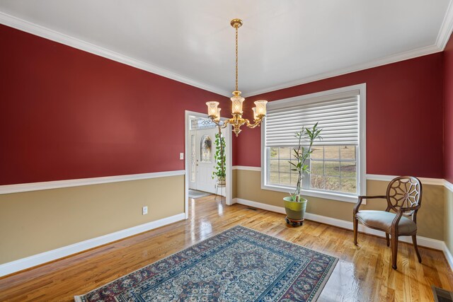 sitting room with baseboards, ornamental molding, a chandelier, and wood finished floors