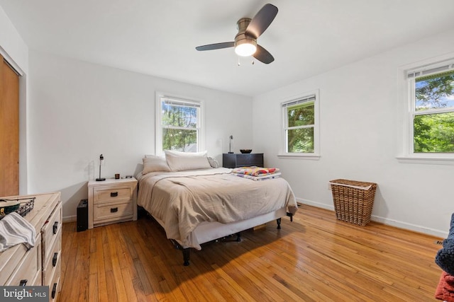  - bedroom with multiple windows, light wood-type flooring, a ceiling fan, and a closet