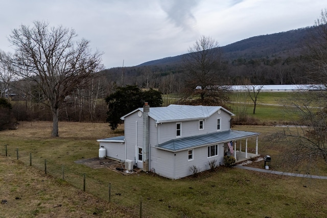 15745 Runions Creek Rd, Broadway, VA 22815 - rear view of house featuring a chimney, a yard, fence, metal roof, and a porch