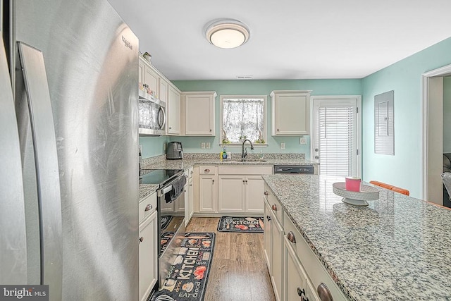 307 Cardinal, Louisa, VA 23093 - kitchen with stainless steel appliances, light wood-type flooring, white cabinets, and light stone counters