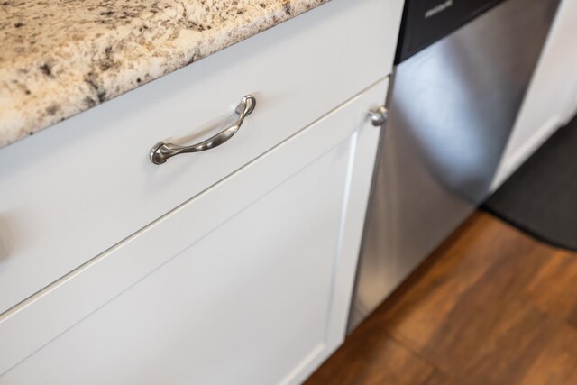 kitchen view of light stone counters and dark wood finished floors