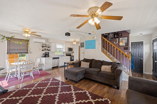 living area featuring a wall mounted air conditioner, ceiling fan, and wood finished floors