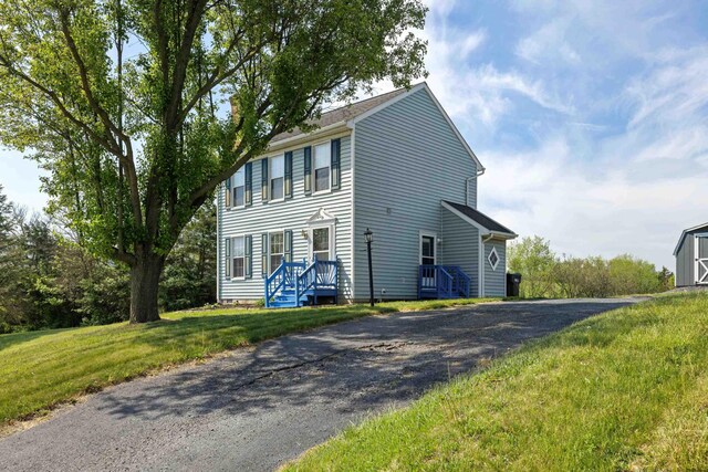 view of front facade featuring driveway and a front yard